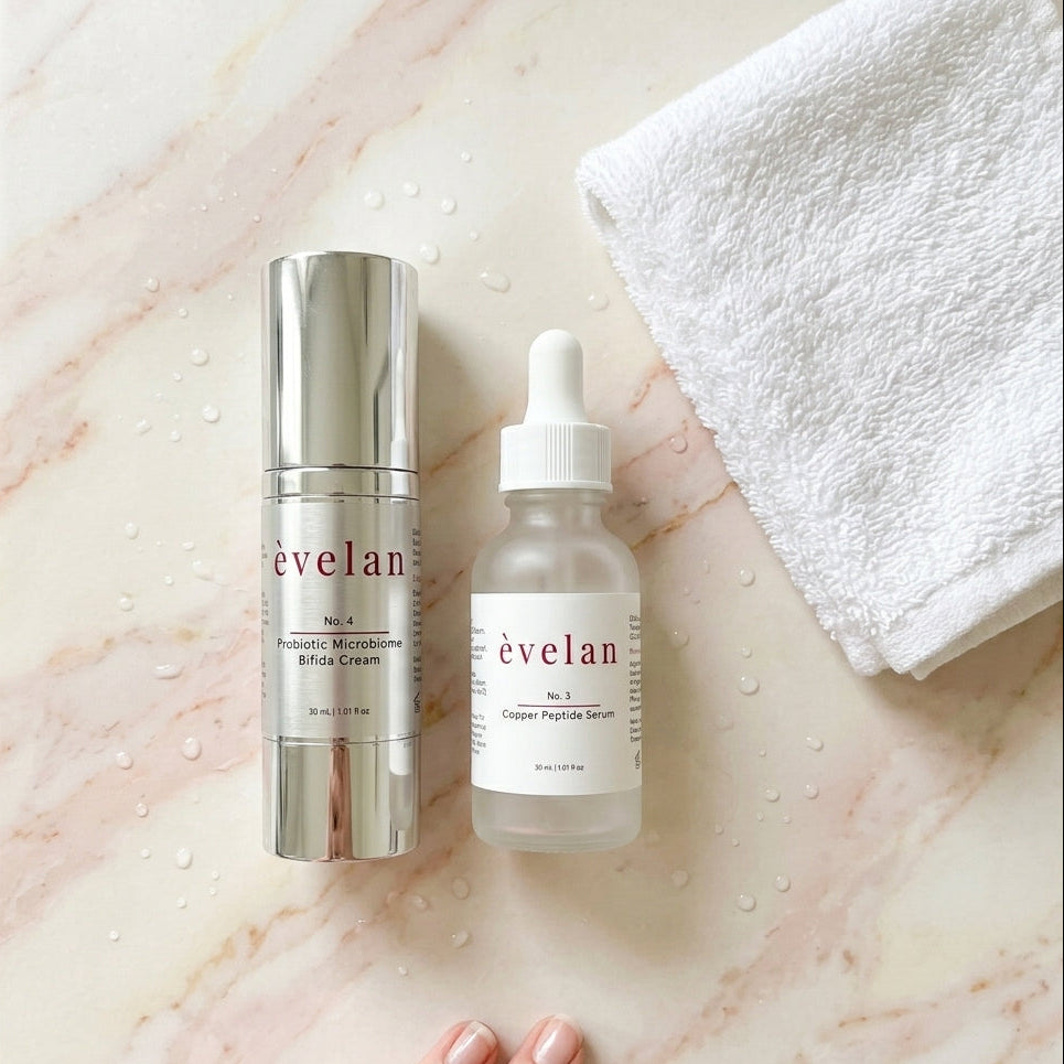 Two skincare products from the brand 'evelan' on a marble surface with a hand and towel.
